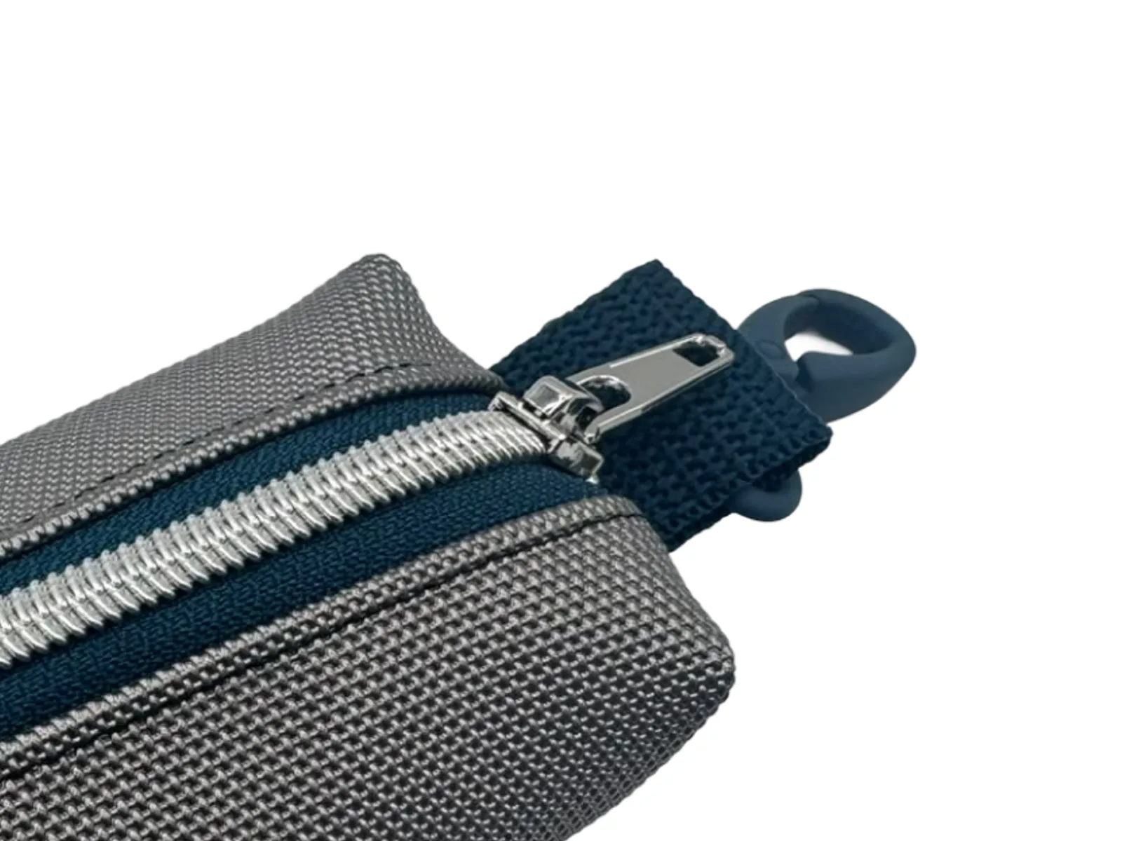 Detail: Zipper und navyblauer Karabiner am grauen Täschchen